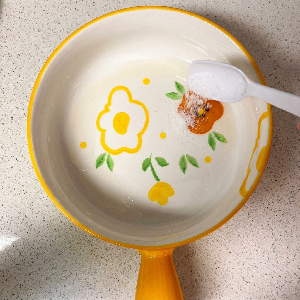Eine kleine Schüssel mit einer Mischung aus Sojasaucen, Zucker, Salz, Stärke und Wasser, die mit einem Löffel verrührt wird.