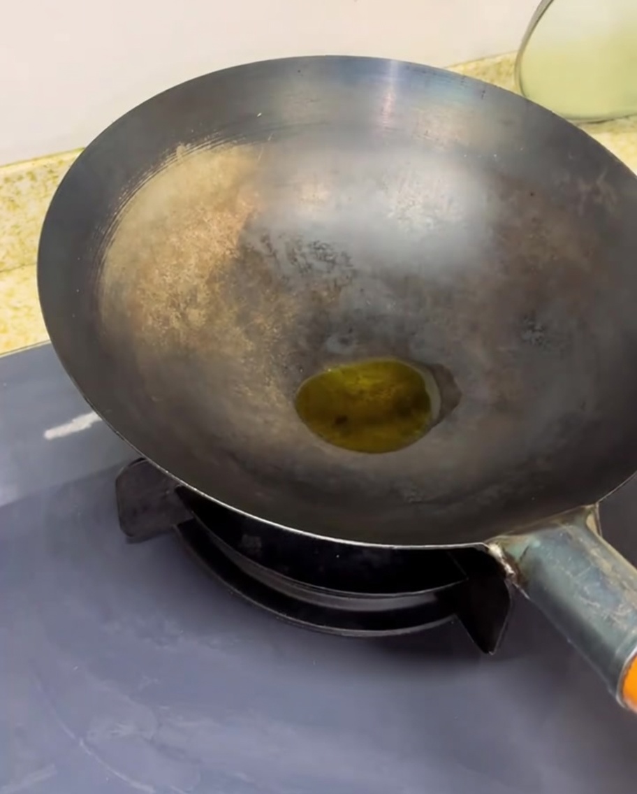 Gehackte Tomaten braten in einem heißen Wok, wobei Dampf aufsteigt und die Flüssigkeit reduziert wird.