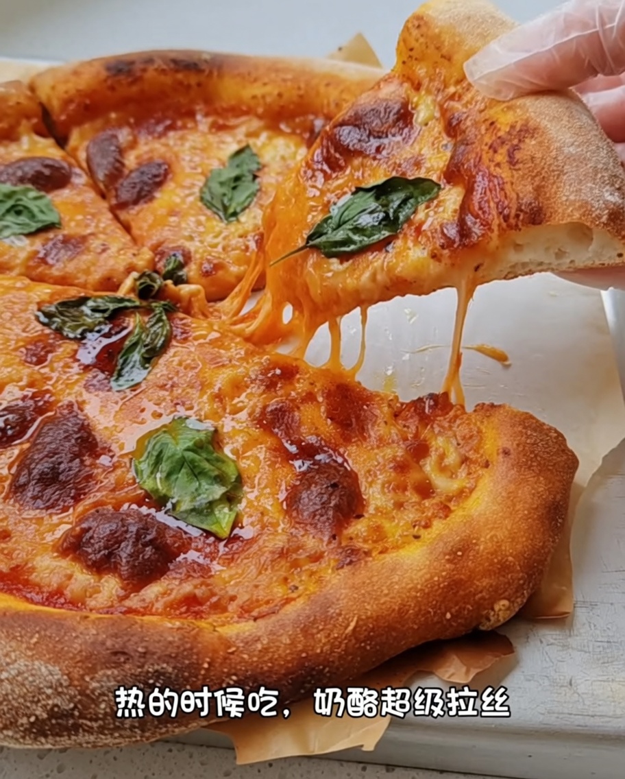 Hände dehnen den Pizzateig vorsichtig über den Knöcheln aus.