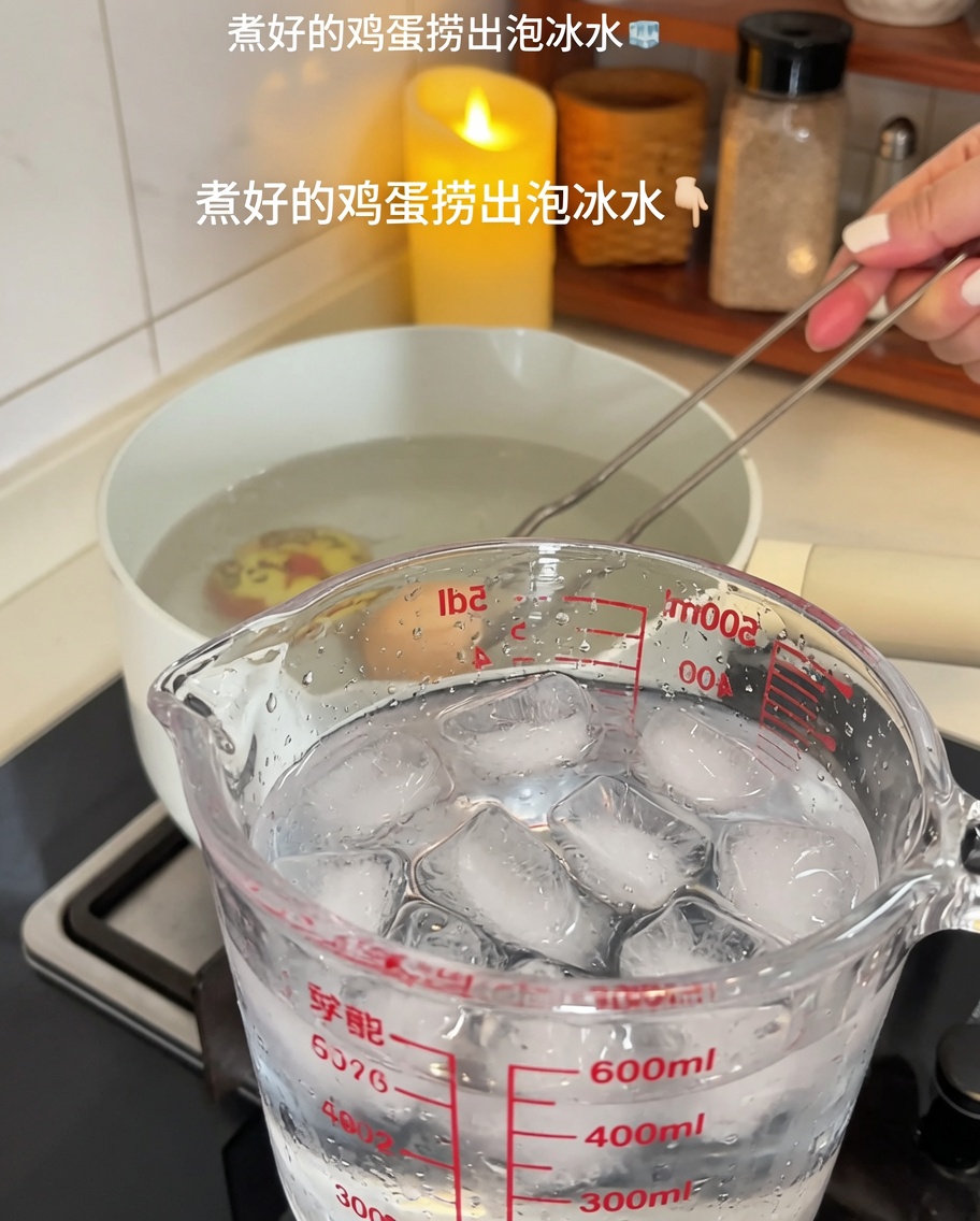 Gekochte Eier werden in ein Glas mit Eiswasser überführt.
