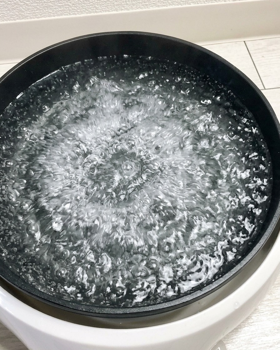 Fünf rohe Eier werden vorsichtig in einen Topf mit kochendem Wasser gegeben.