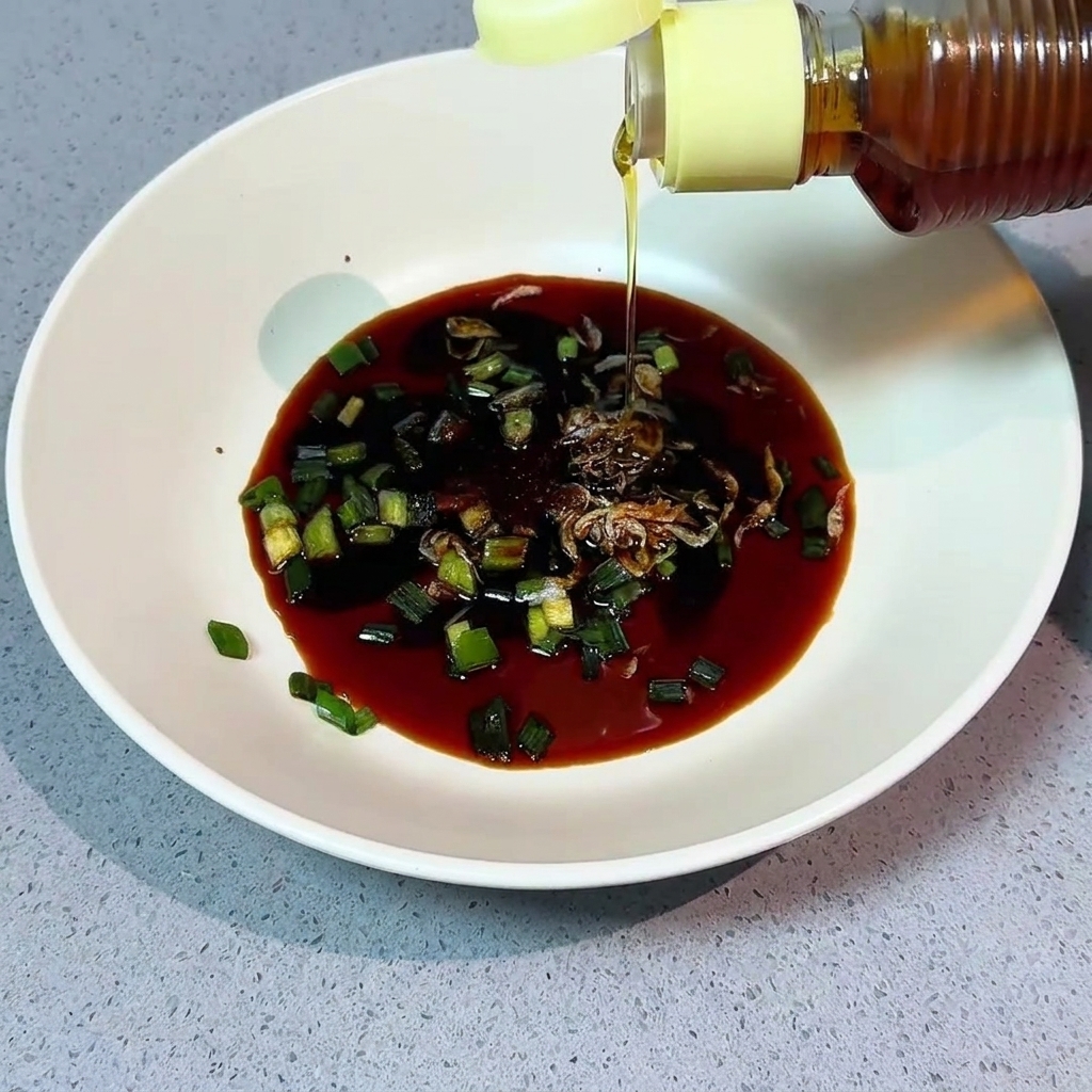 Sesamöl wird aus einer Flasche in eine Schüssel mit verschiedenen Gewürzen geträufelt.