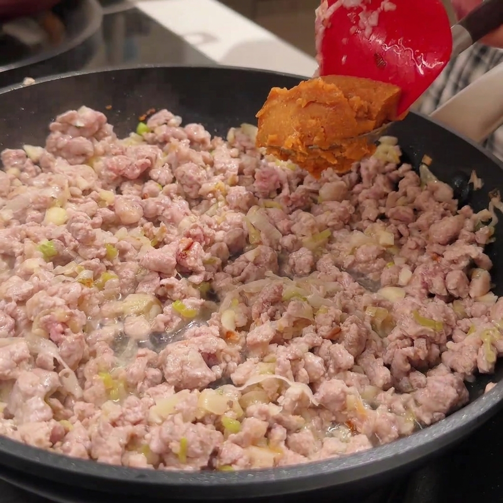 Miso-Paste wird zum Fleisch in die Pfanne gegeben.