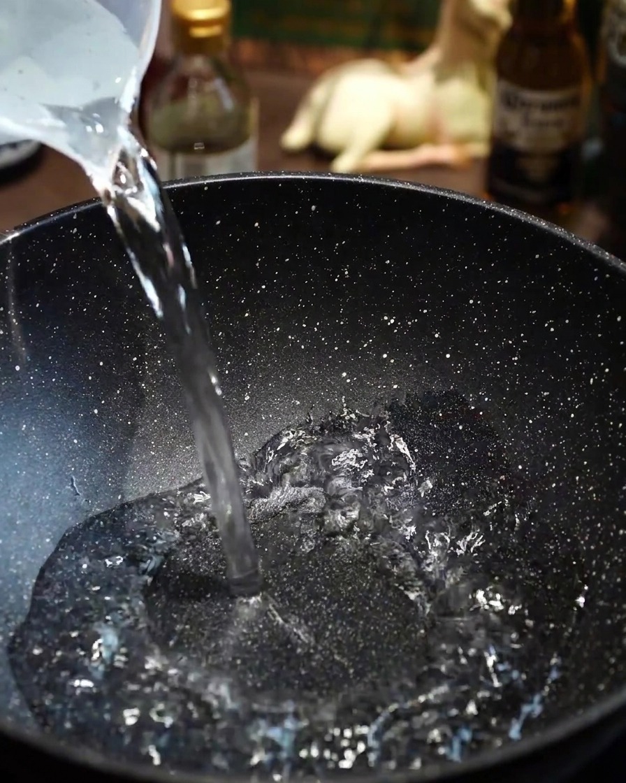 Dünne Wagyu-Rindfleischscheiben werden vorsichtig in kochendes Wasser in der Pfanne gegeben.