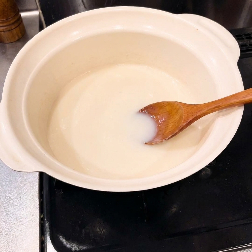 Zwiebelstücke werden in einem Keramiktopf angebraten.