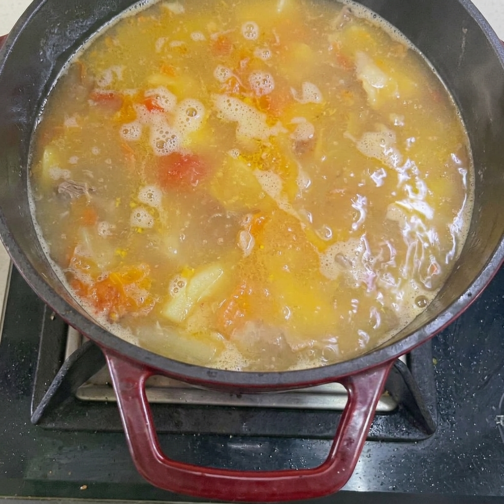 Kochendes Wasser wird in den Topf mit Fleisch und Gemüse gegossen.