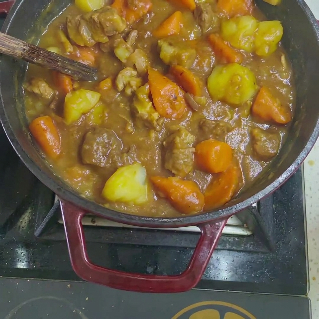 Feste Curry-Würfel werden in den gekochten Rindfleisch- und Gemüseeintopf gegeben.
