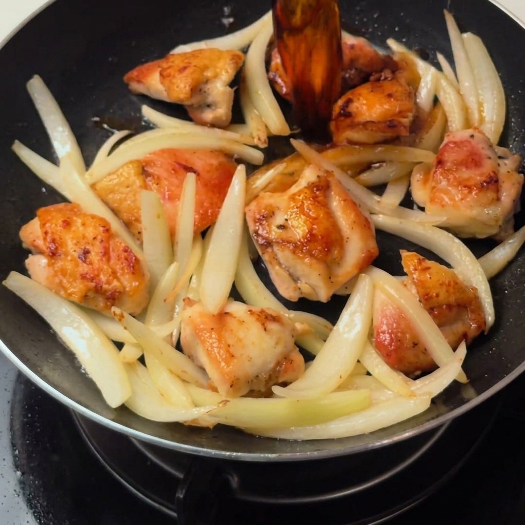 Hähnchen und Zwiebeln schmoren in der herzhaften Dashi-Soße in der Pfanne.