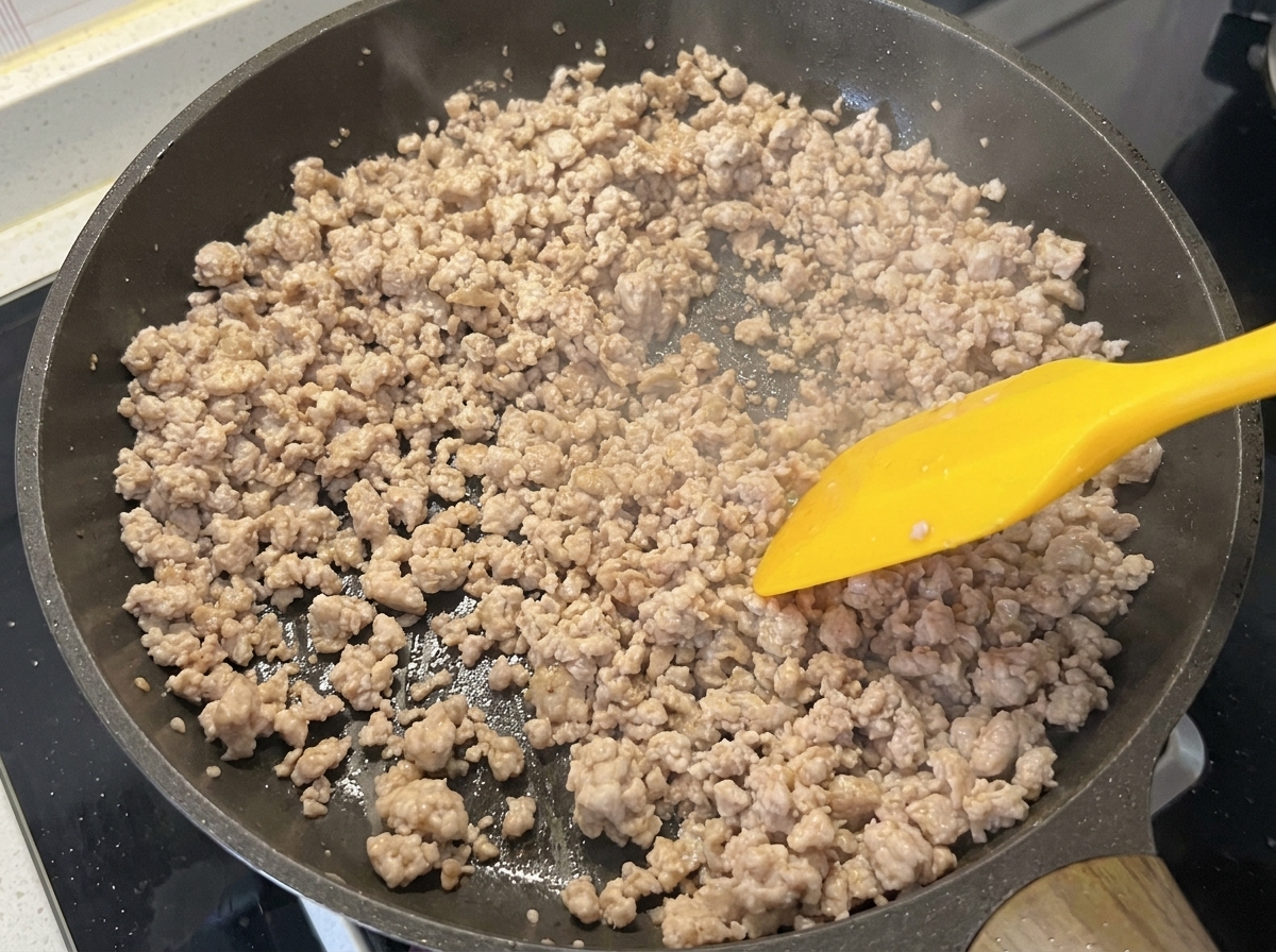 Das Schweinehackfleisch in der Pfanne, braun und trocken nach dem Anbraten.