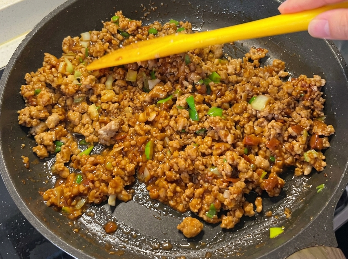 Die Fleischsauce ist in der Pfanne eingedickt und glänzend.