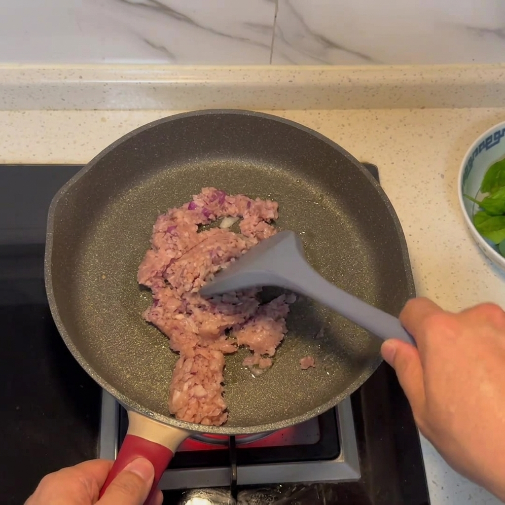 Hackfleisch-Zwiebel-Mischung bräunt in einer Pfanne.