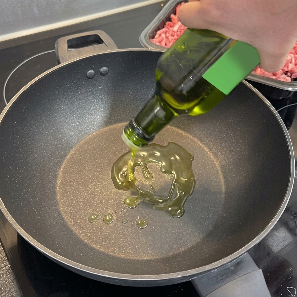 Duftende Knoblauch- und Chilimischung zischt in einem heißen Wok mit Öl.