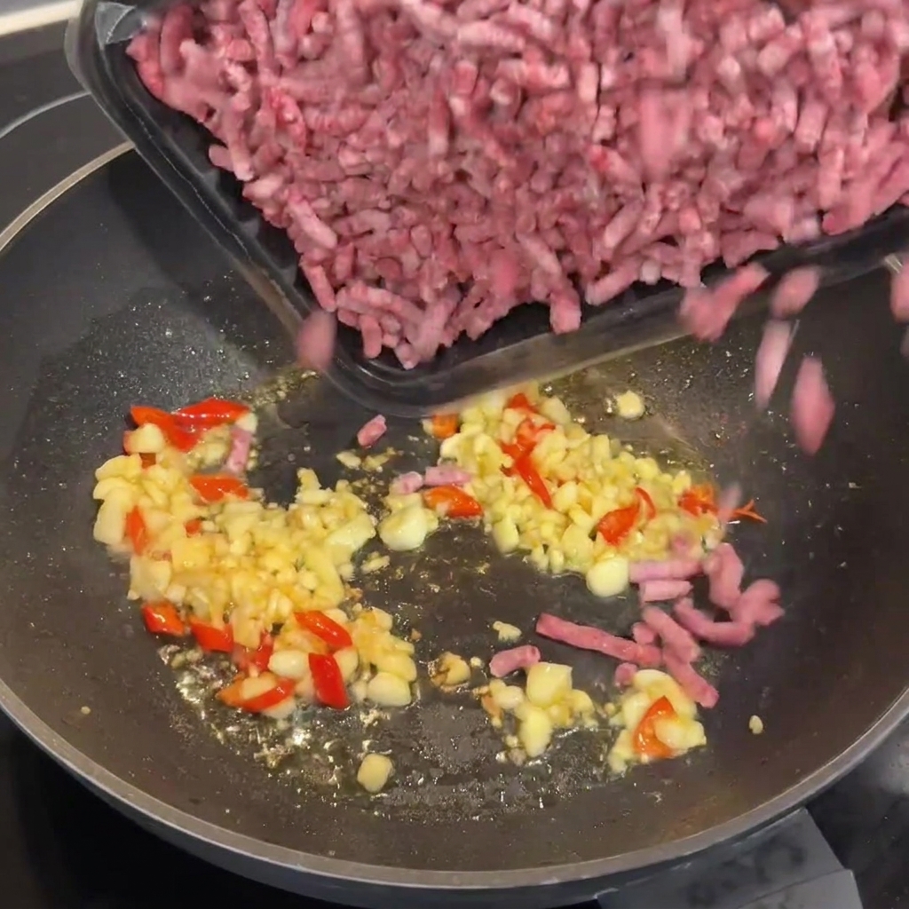 Rohes Wagyu-Rinderhackfleisch wird in den heißen Wok zu den Aromen gegeben.