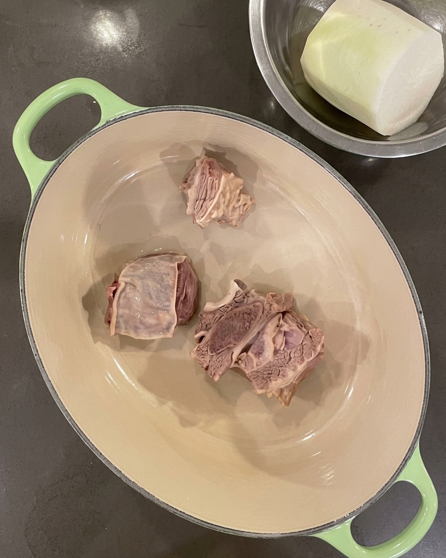 Gereinigte Rippchen liegen am Boden eines leeren gusseisernen Topfes.