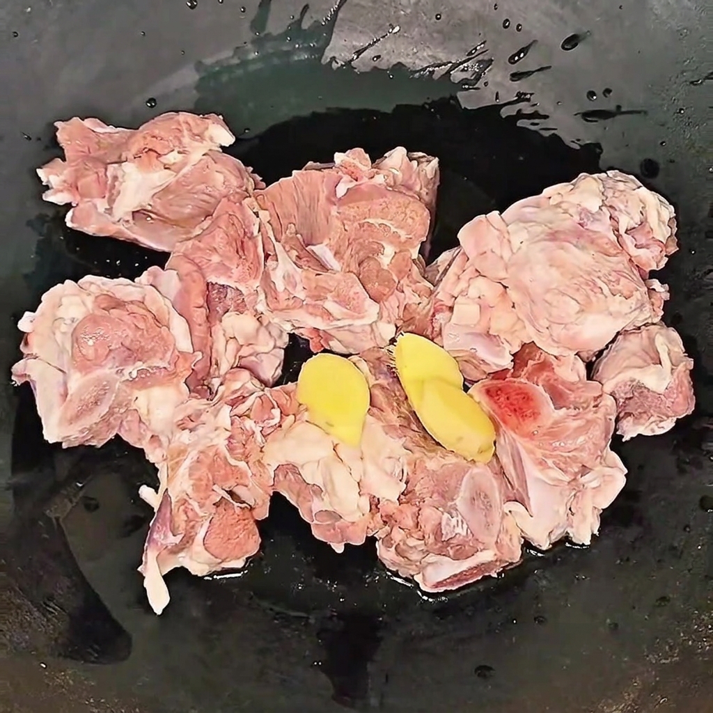 Rinderrippchen köcheln in einem Topf mit Ingwerscheiben und Kochwein während des Blanchiervorgangs.