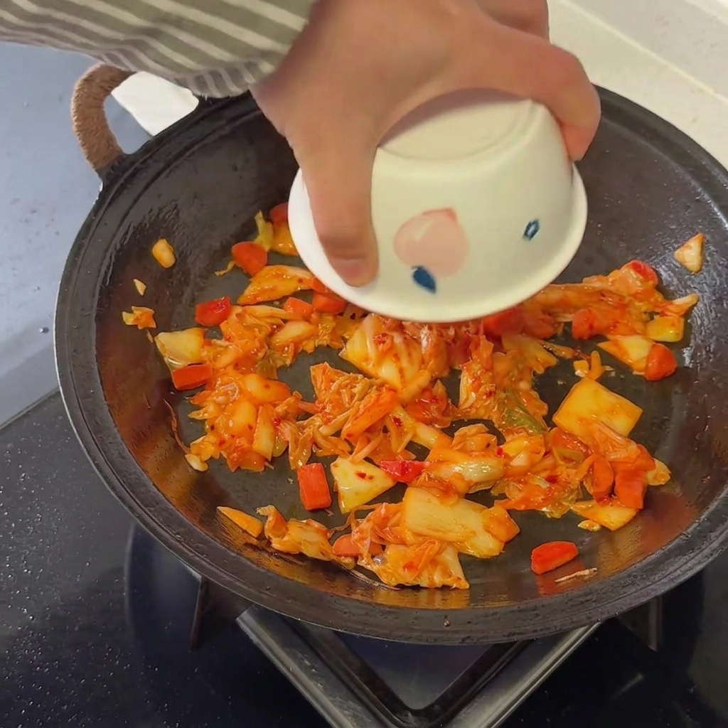 Gekochter Reis wird gründlich unter die Kimchi-Wurst-Mischung gehoben.