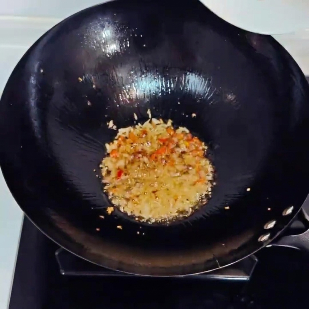 Gehackter Kimchi und gewürfelter Schinken werden mit den Aromen im Wok angebraten.