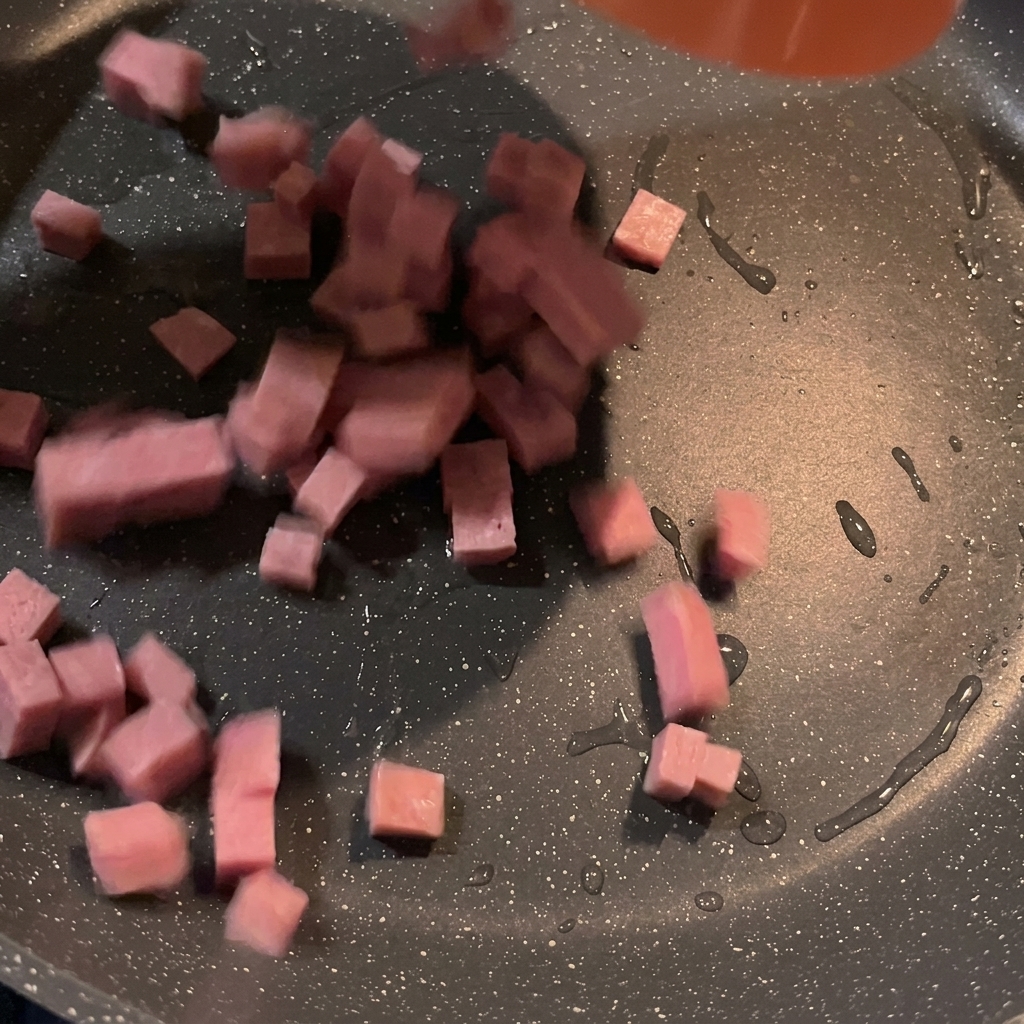 Spam-Würfel, die in einer heißen Pfanne goldbraun braten.