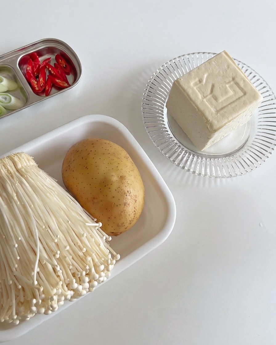 Festes Tofu-Stück auf einem Holzbrett, bereit zum Schneiden.