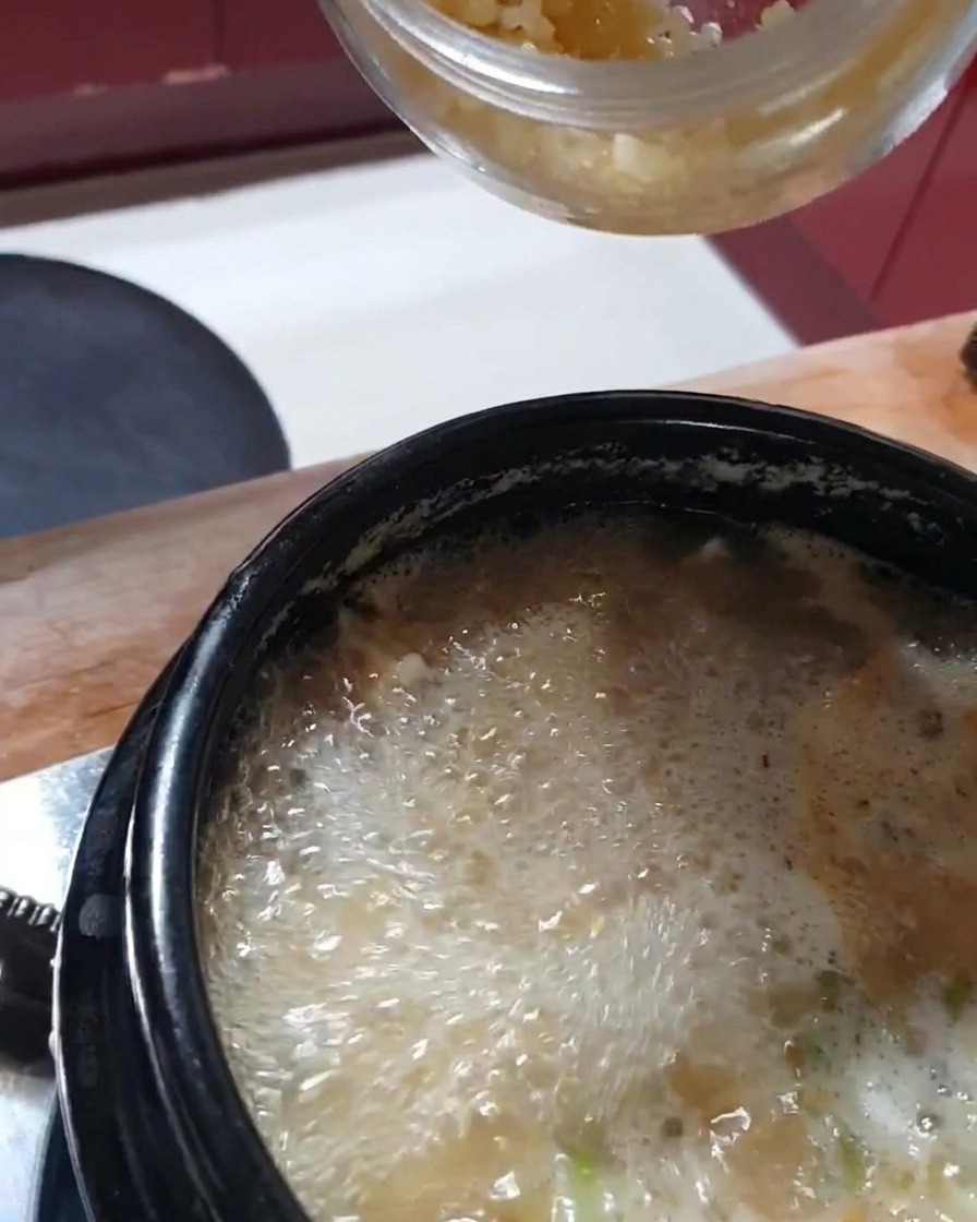 Frisch gehackter Knoblauch wird in den Eintopf gegeben.