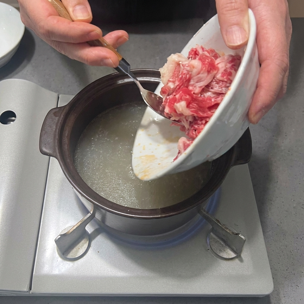 Frische Rinderbrustscheiben werden in den Topf mit der gewürzten Brühe gegeben.