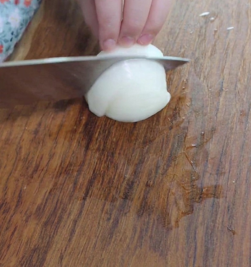 Gewürfelte Zwiebelstücke auf einem Holzbrett.
