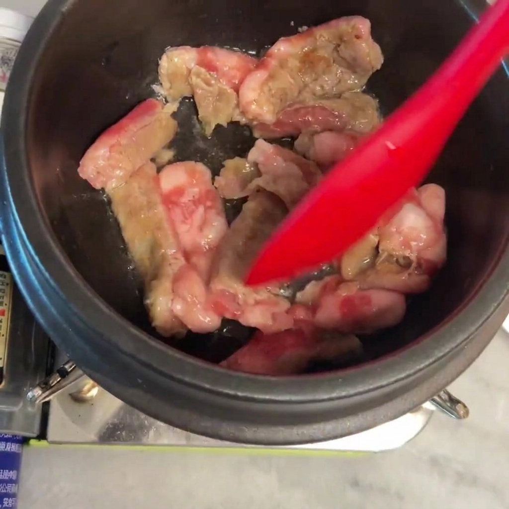 Rindfleisch wird in einem heißen Topf angebraten und gewendet.