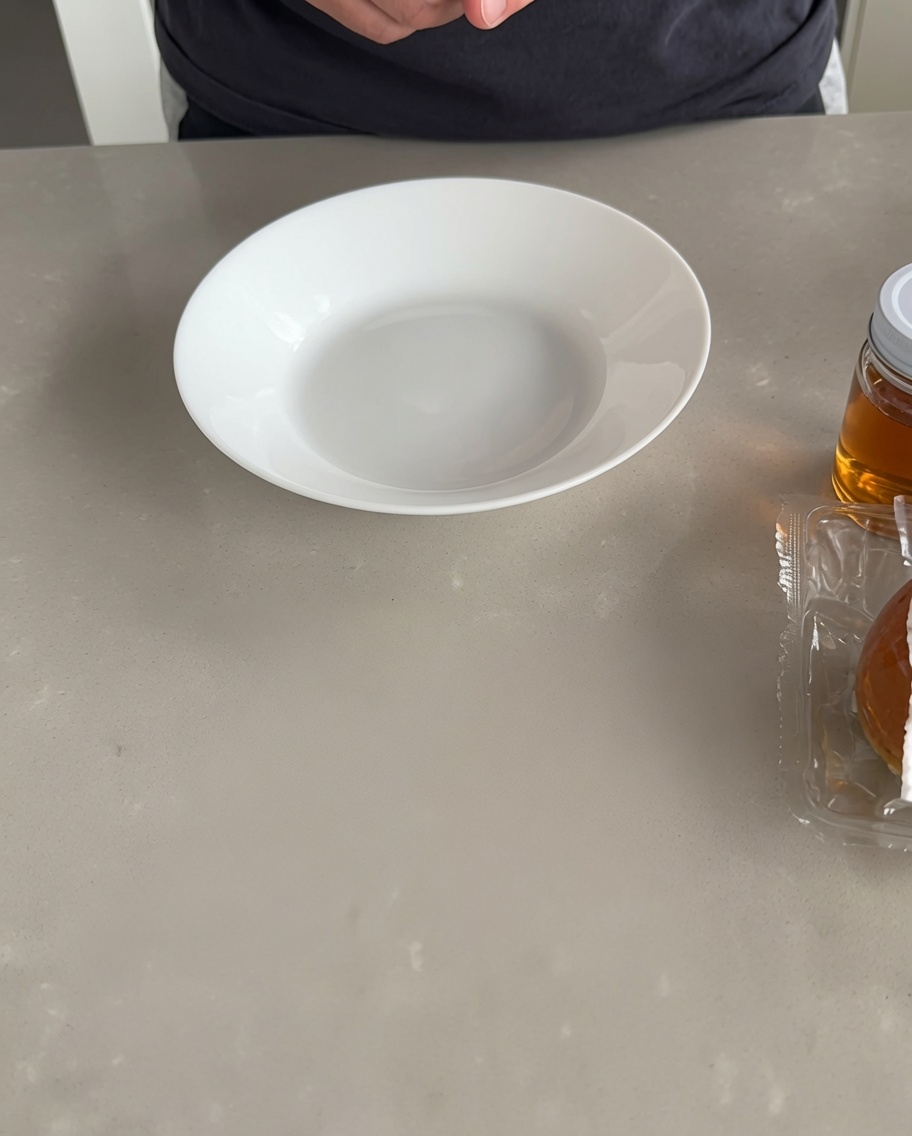 Zwei rohe Rinderfleischbällchen liegen auf einer sauberen, hellen Küchenarbeitsplatte.
