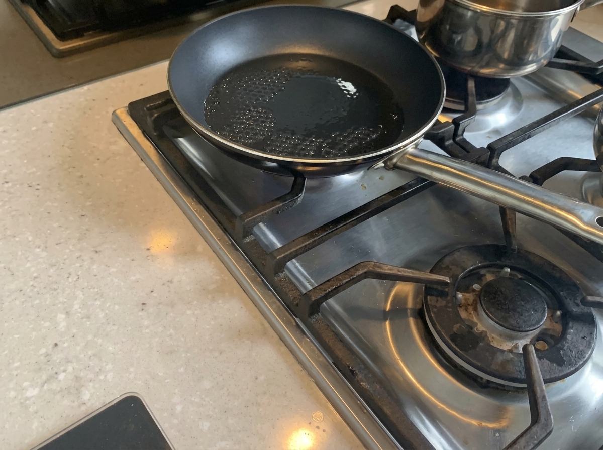 Gehackte Zwiebeln werden in einer Pfanne mit heißem Öl weich gedünstet.