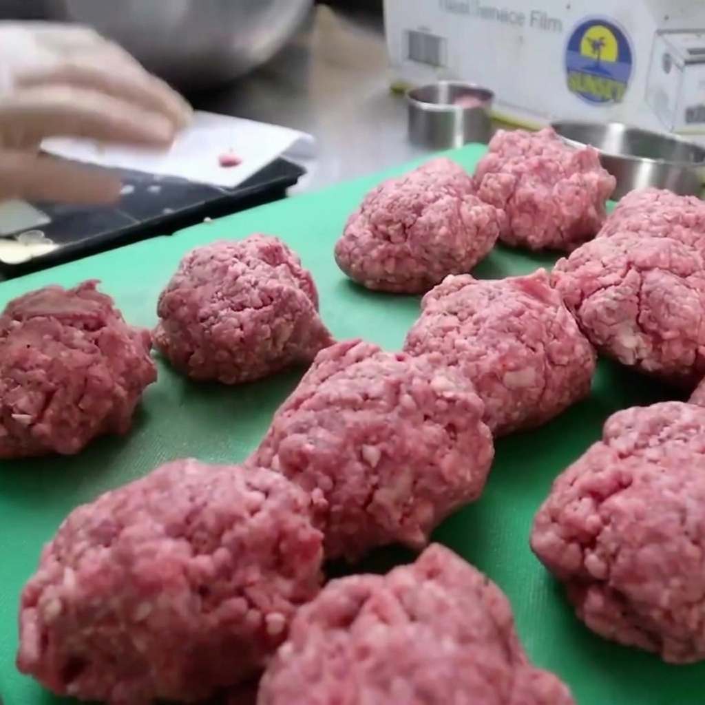 Bison-Hackfleisch wird in eine runde Form gepresst, um dicke Burger-Patties zu formen.