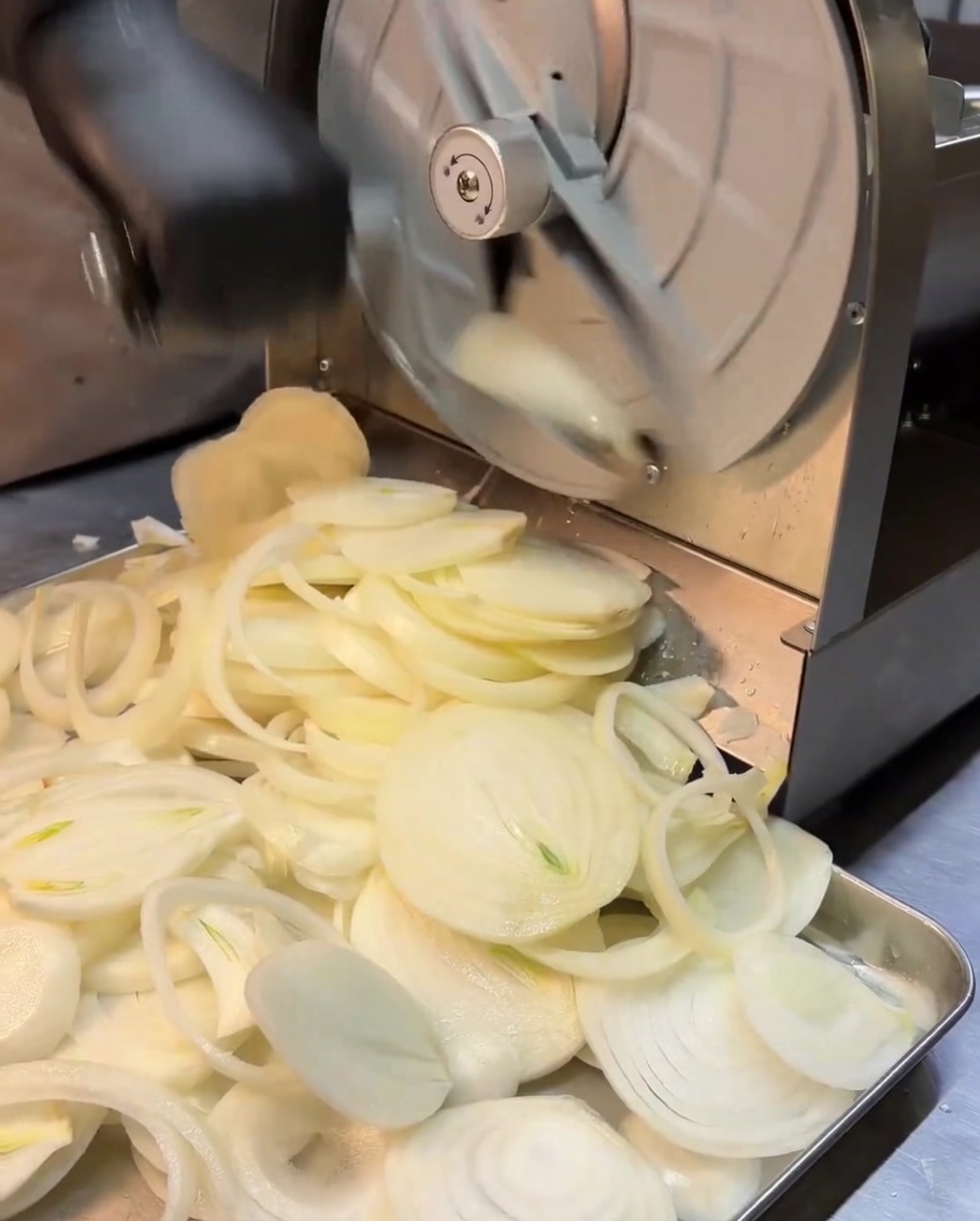 Feine Zwiebelstreifen werden mit einem Gemüsehobel verarbeitet.