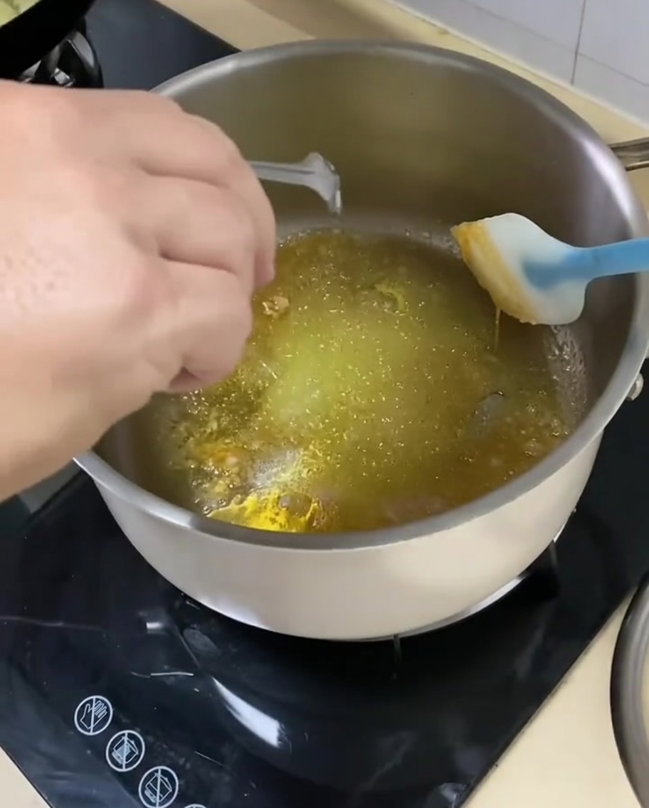 Geschnittene Zwiebeln werden zusammen mit der Karamellbasis und Gewürzen in die Pfanne gegeben.