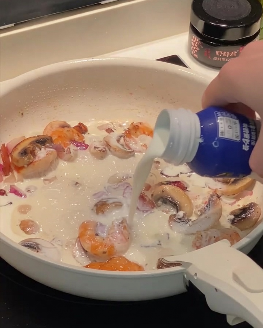 Sahne und Milch werden in die Pfanne zu den restlichen Zutaten gegossen.