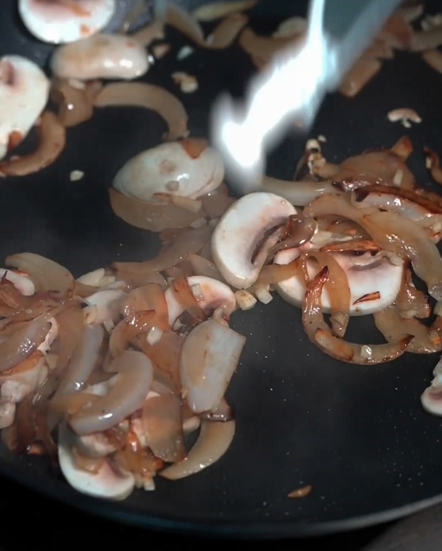 Eine Mischung aus frischen Champignons und Buchenpilzen, die in einer Pfanne angebraten werden.