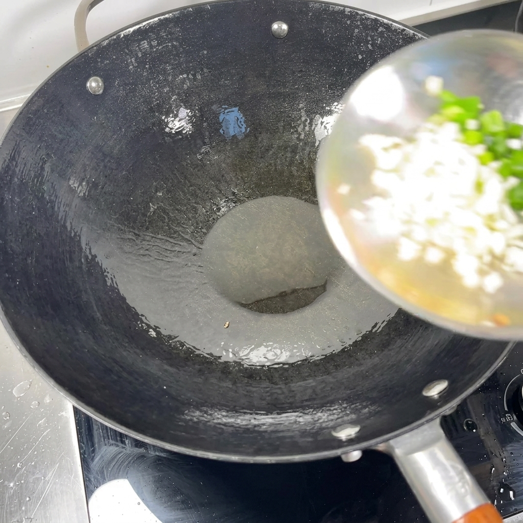Gehackte Frühlingszwiebeln und Knoblauch werden in einen heißen Wok mit Öl gegeben.