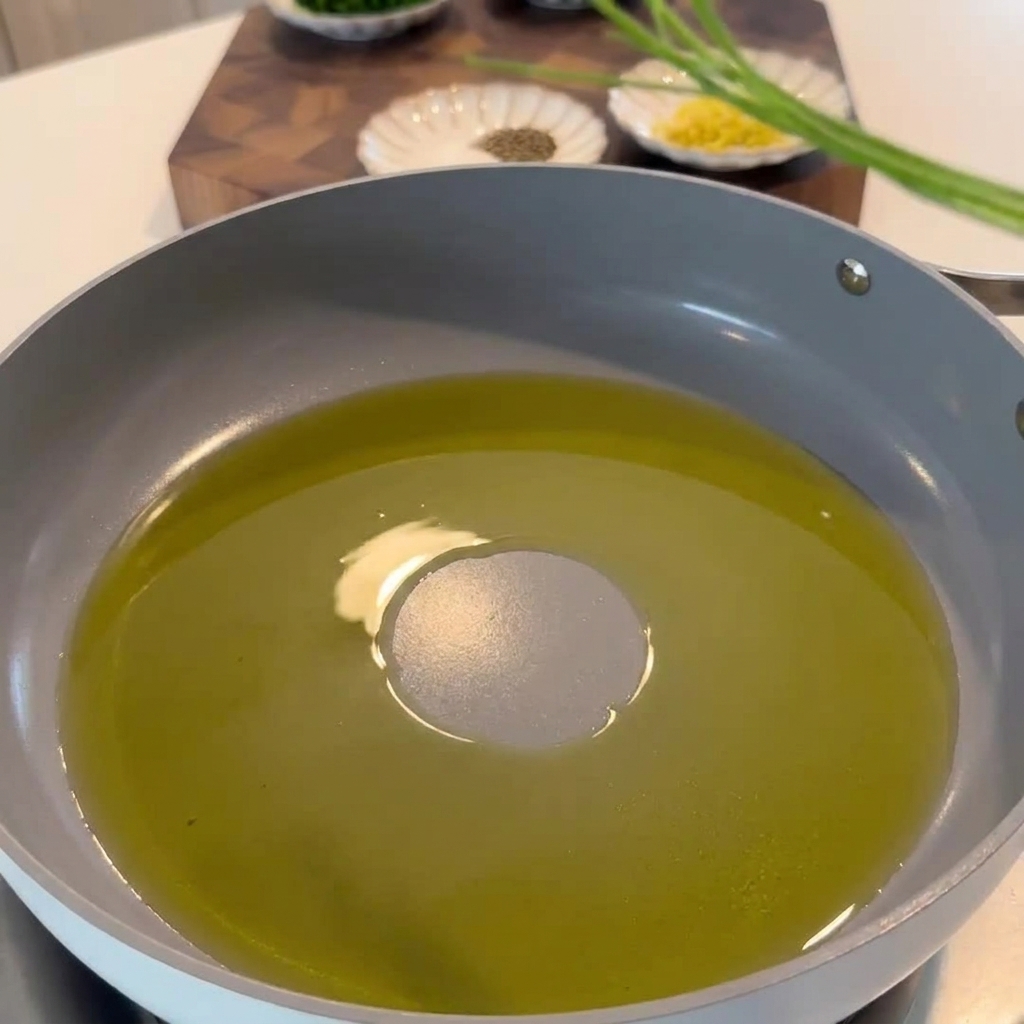 Petersilienstiele, Zitronenzeste und Chiliflocken werden in der Pfanne mit dem aromatisierten Olivenöl geschwenkt.