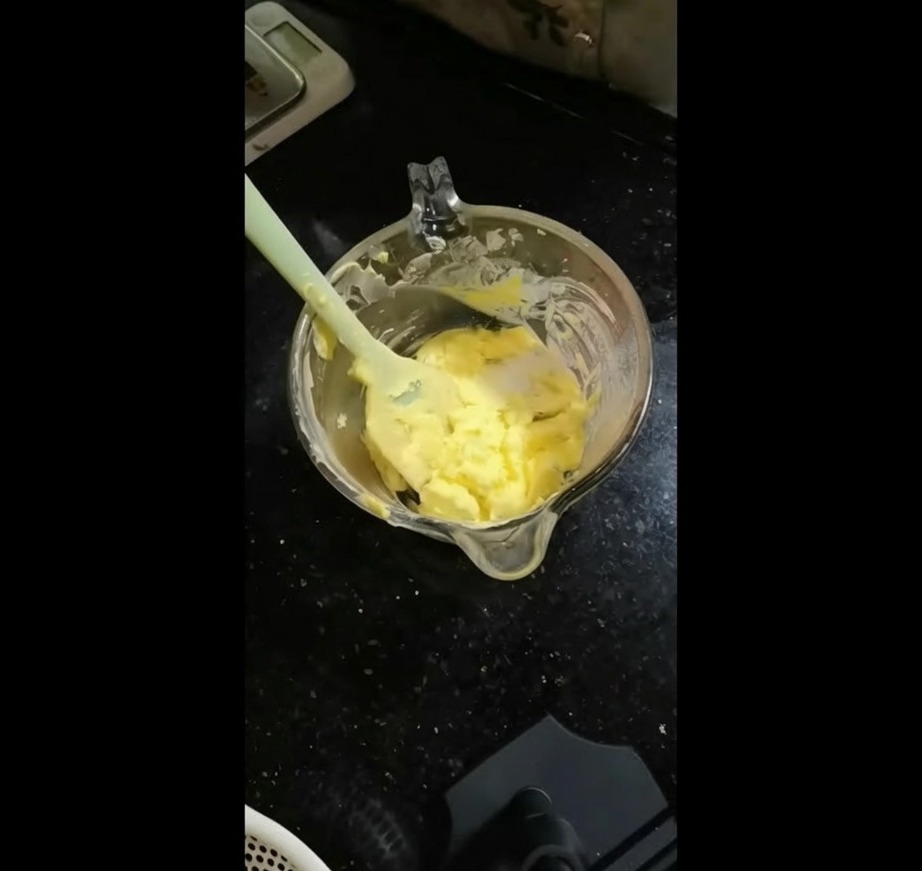 Die gehackte grüne Kräutermischung wird in eine Schüssel mit weicher gelber Butter gegeben.