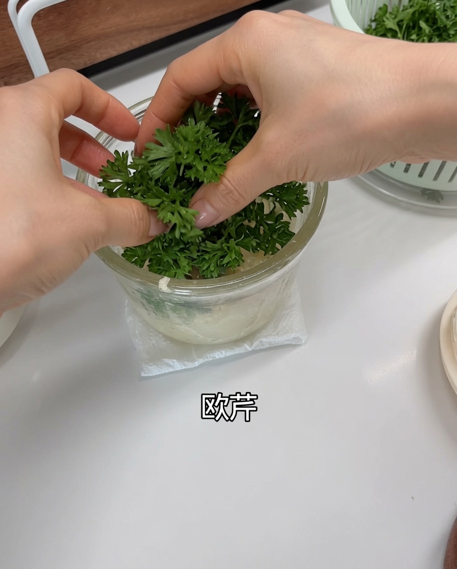 Frische Petersilie im Zerkleinerer über dem Knoblauch und den Schalotten.
