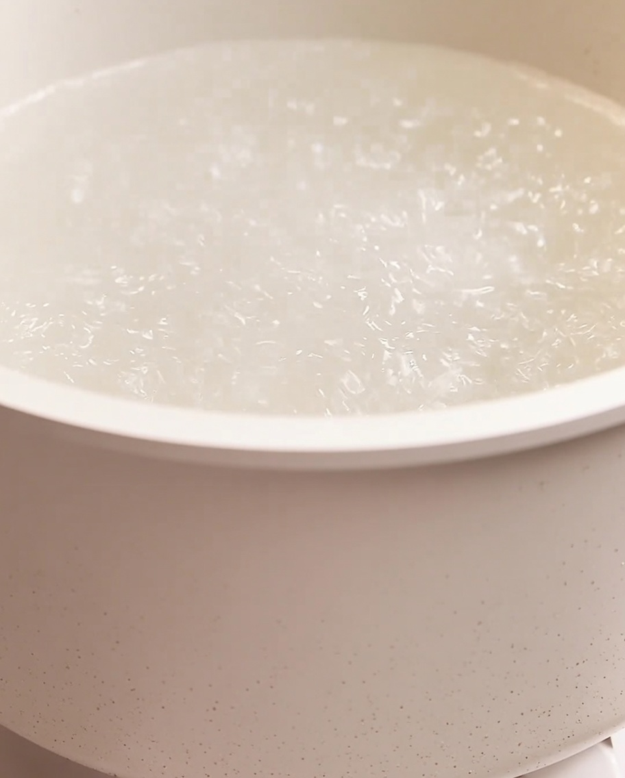 Spaghetti kochen in einem großen Topf mit sprudelnd kochendem Wasser.