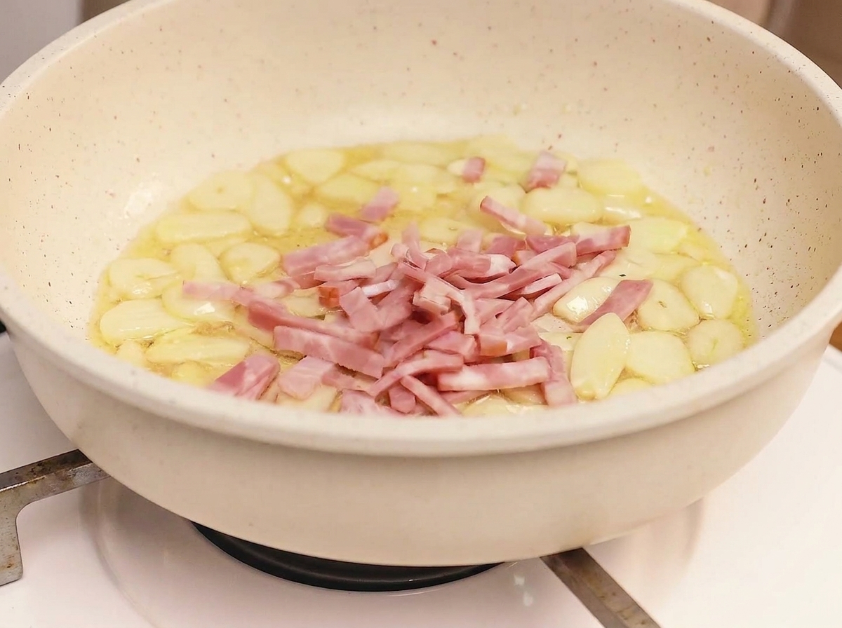 Speckstreifen braten in einer Pfanne mit Knoblauch goldbraun und knusprig.