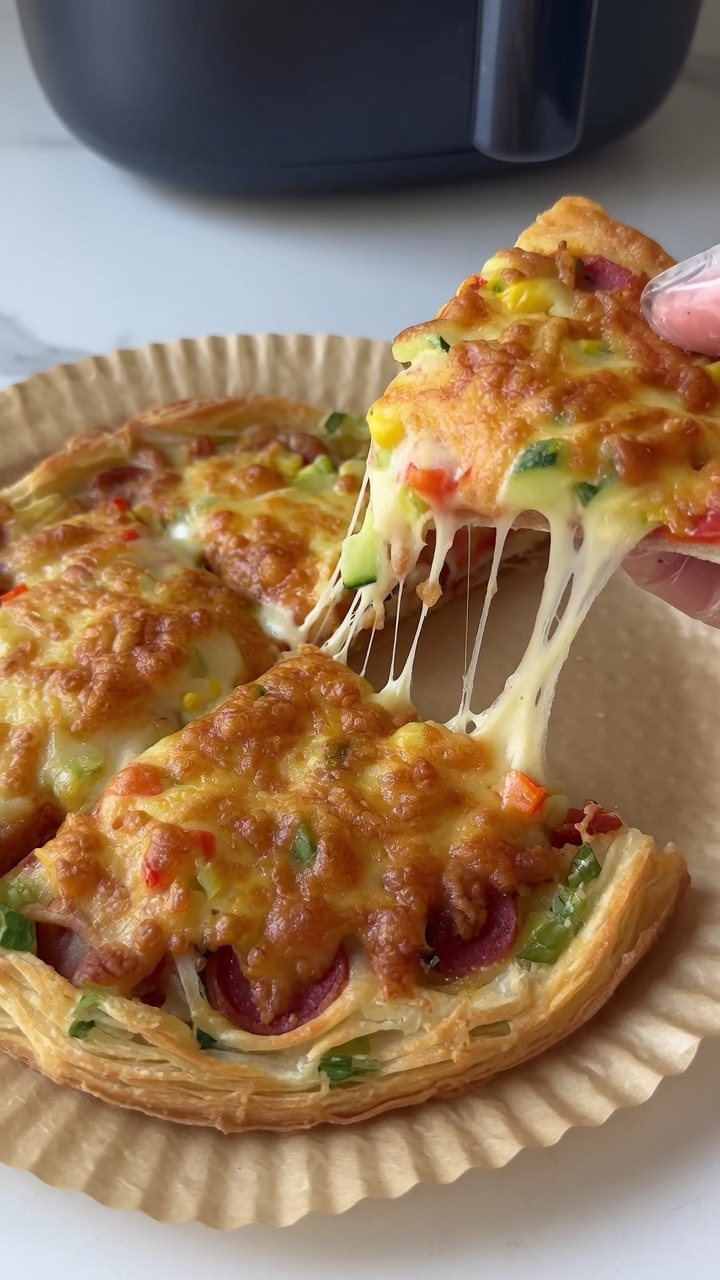 Ein Stück frisch gebackene Frühlingszwiebel-Pfannkuchen-Pizza wird angehoben, wobei der geschmolzene, fädige Käse zu sehen ist.