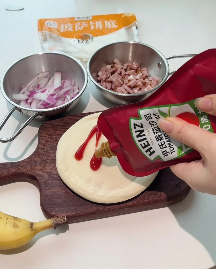 Flaschen mit Ketchup und Salat-Dressing werden auf einen runden Pizzaboden auf einem Holzbrett gedrückt.