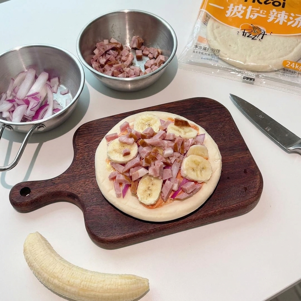 Kleine rohe Speckstücke werden über die mit Bananen und Zwiebeln belegte Pizza gestreut.