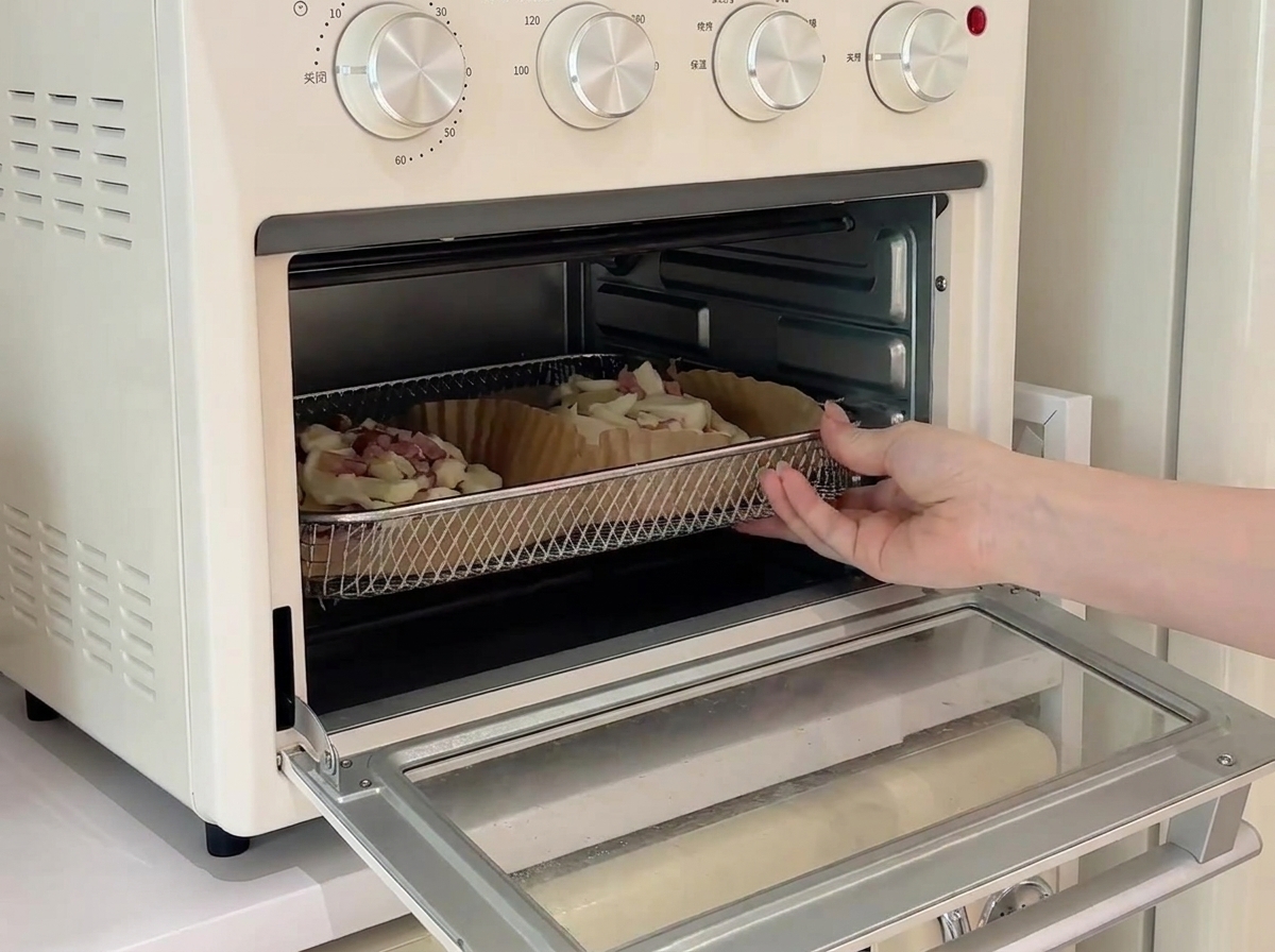 Zwei Mini-Pizzen auf einem Drahtgitter in einem kleinen weißen Miniofen beim Backvorgang.
