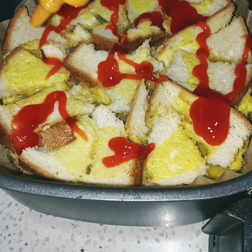 Ein Pinsel verteilt rote Tomatensoße auf der gegarten Brot-Ei-Basis.