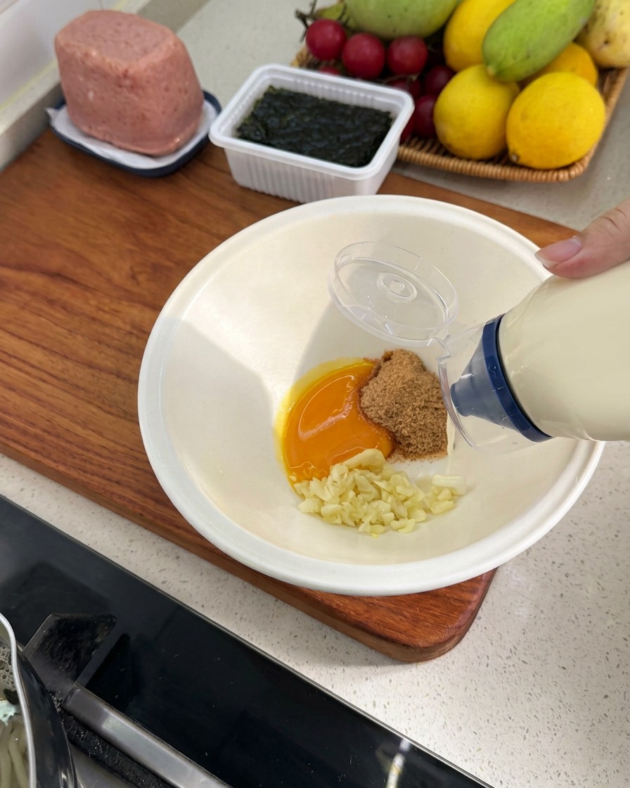 Mayonnaise wird aus einer Quetschflasche zu den restlichen Zutaten in die Schüssel gegeben.