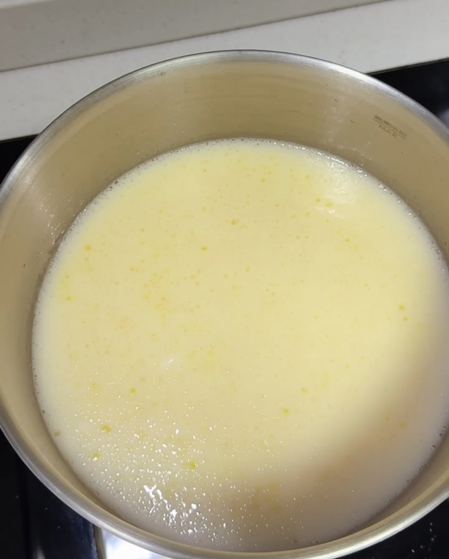 Gekochte Ramen-Nudeln werden in den Topf mit der kochenden cremigen Tonkotsu-Brühe gegeben.