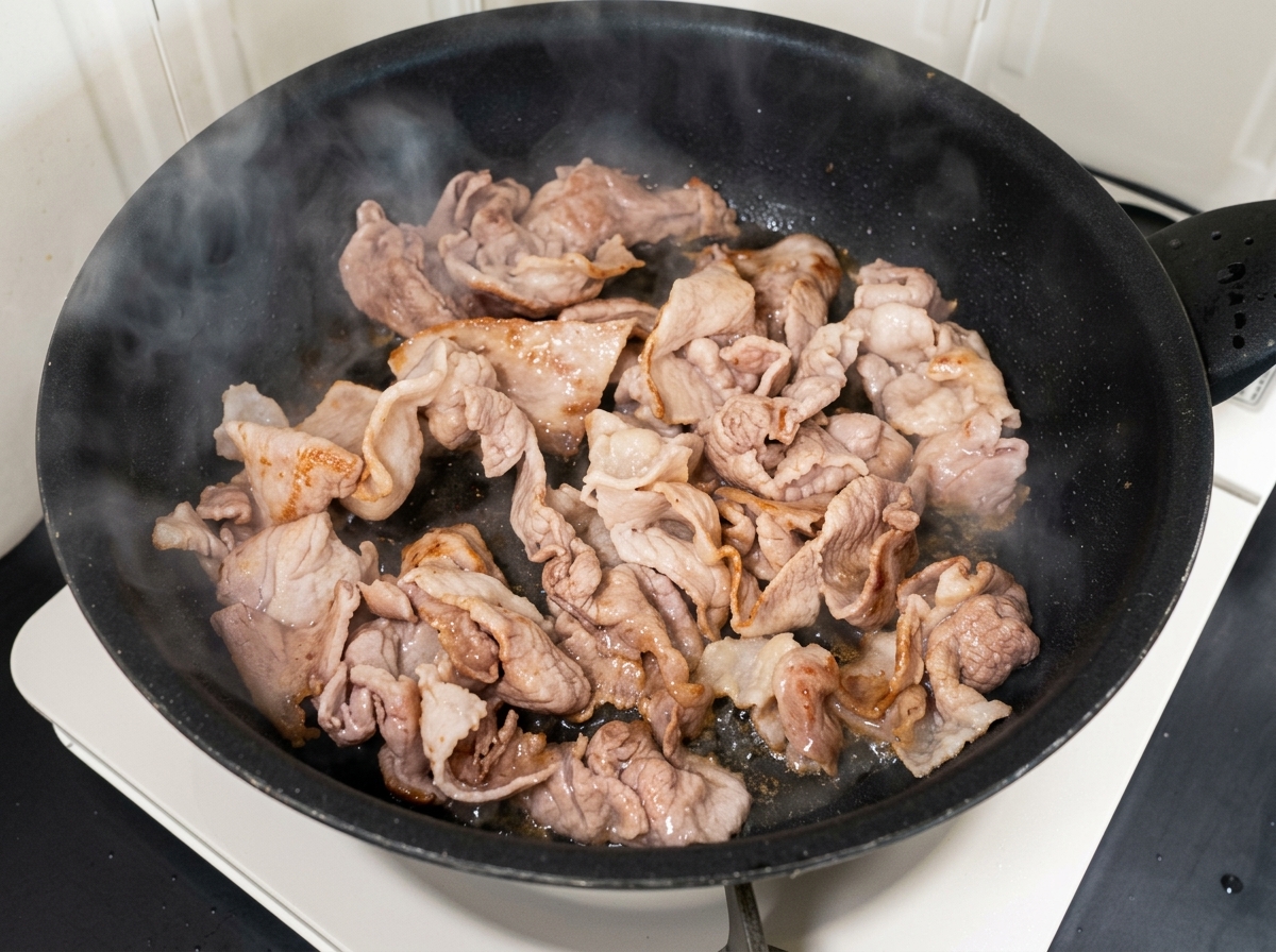 Gehacktes Kimchi und Zucker werden mit dem angebratenen Fleisch vermischt.