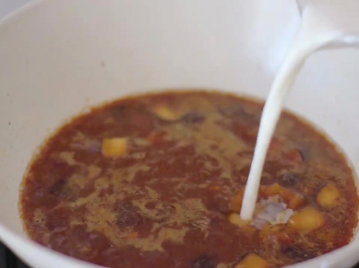 Milch wird in die Miso-Brühe in der Pfanne gegossen.