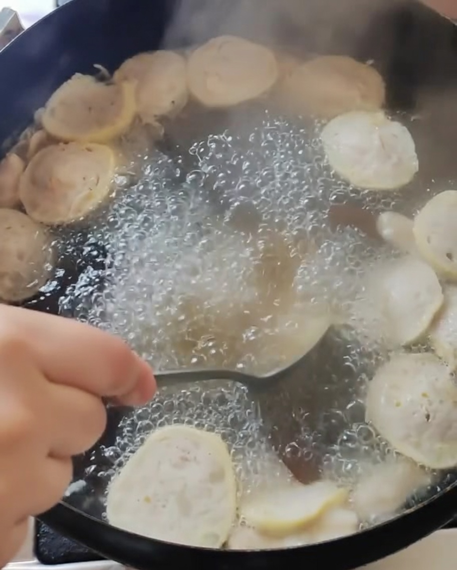 Die Suppe im Topf wird nach dem Würzen umgerührt.